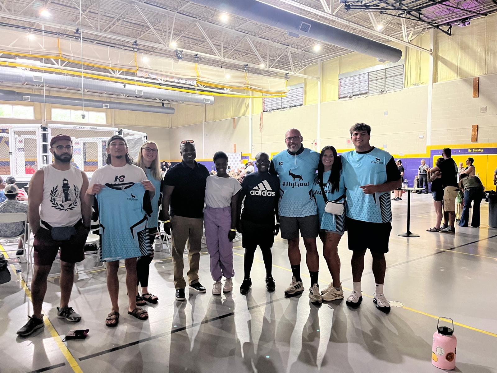 Wrestler Billy Goat holding up a Hamco-sponsored team shirt.