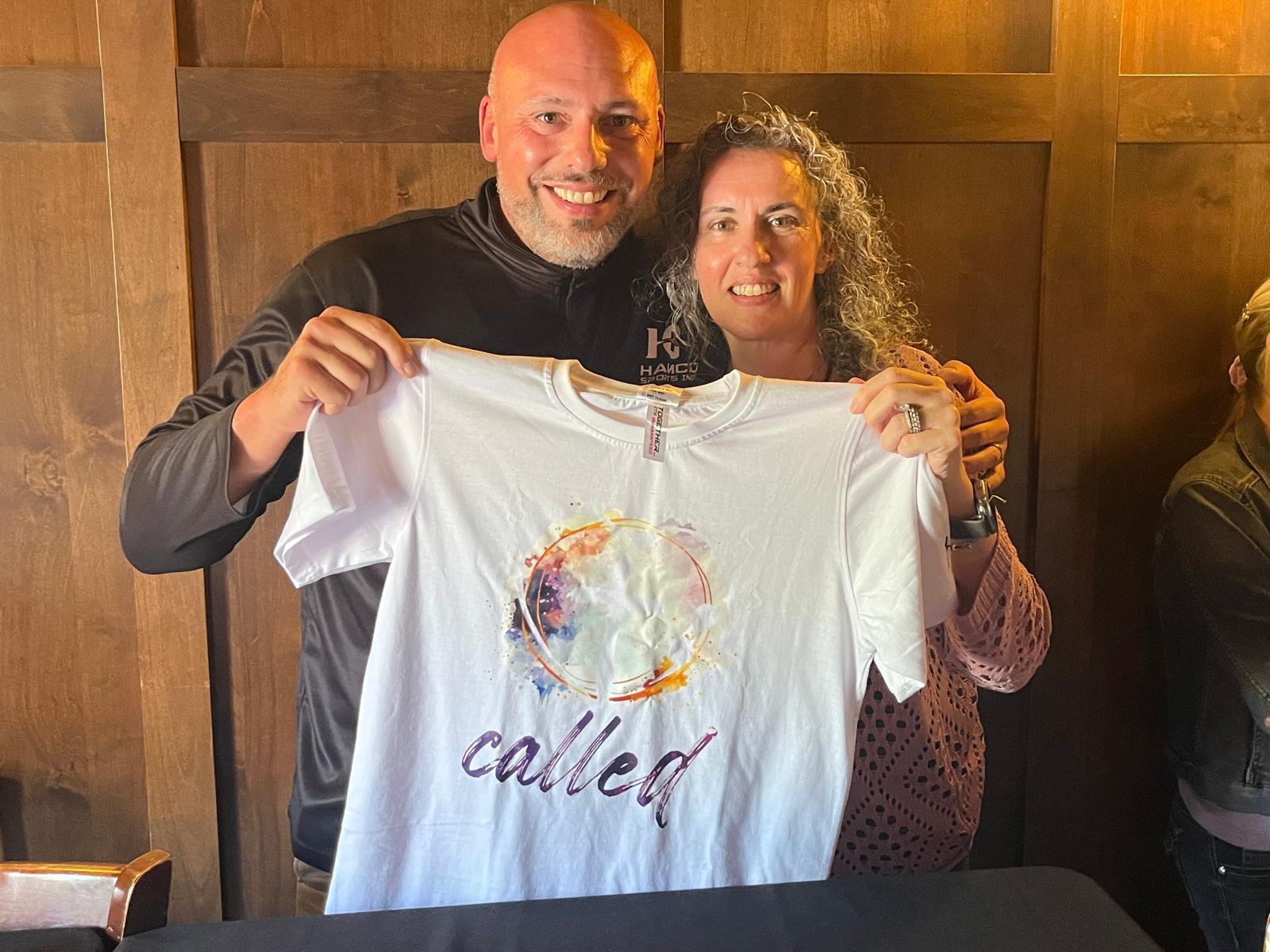 A Hamco representative and a client holding a custom t-shirt together.