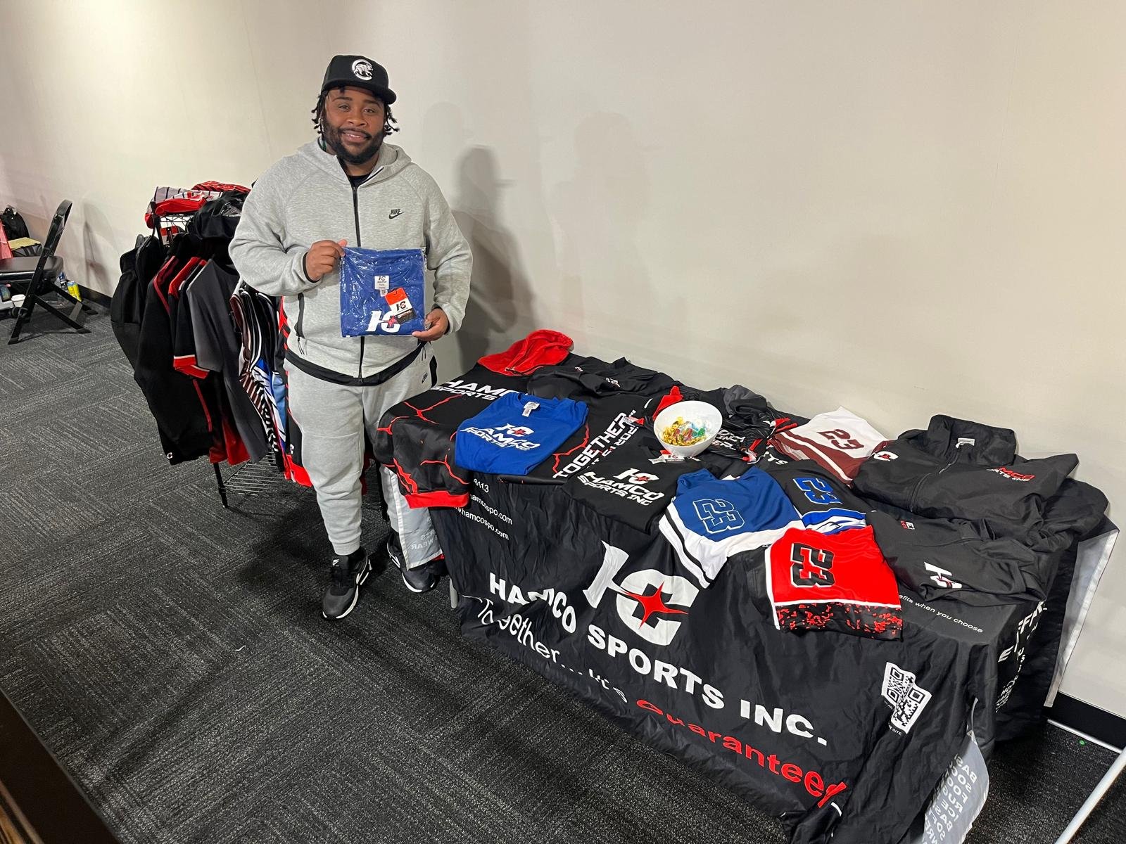 A wrestling club member holding a Hamco giveaway t-shirt at the North Carolina coaches clinic.